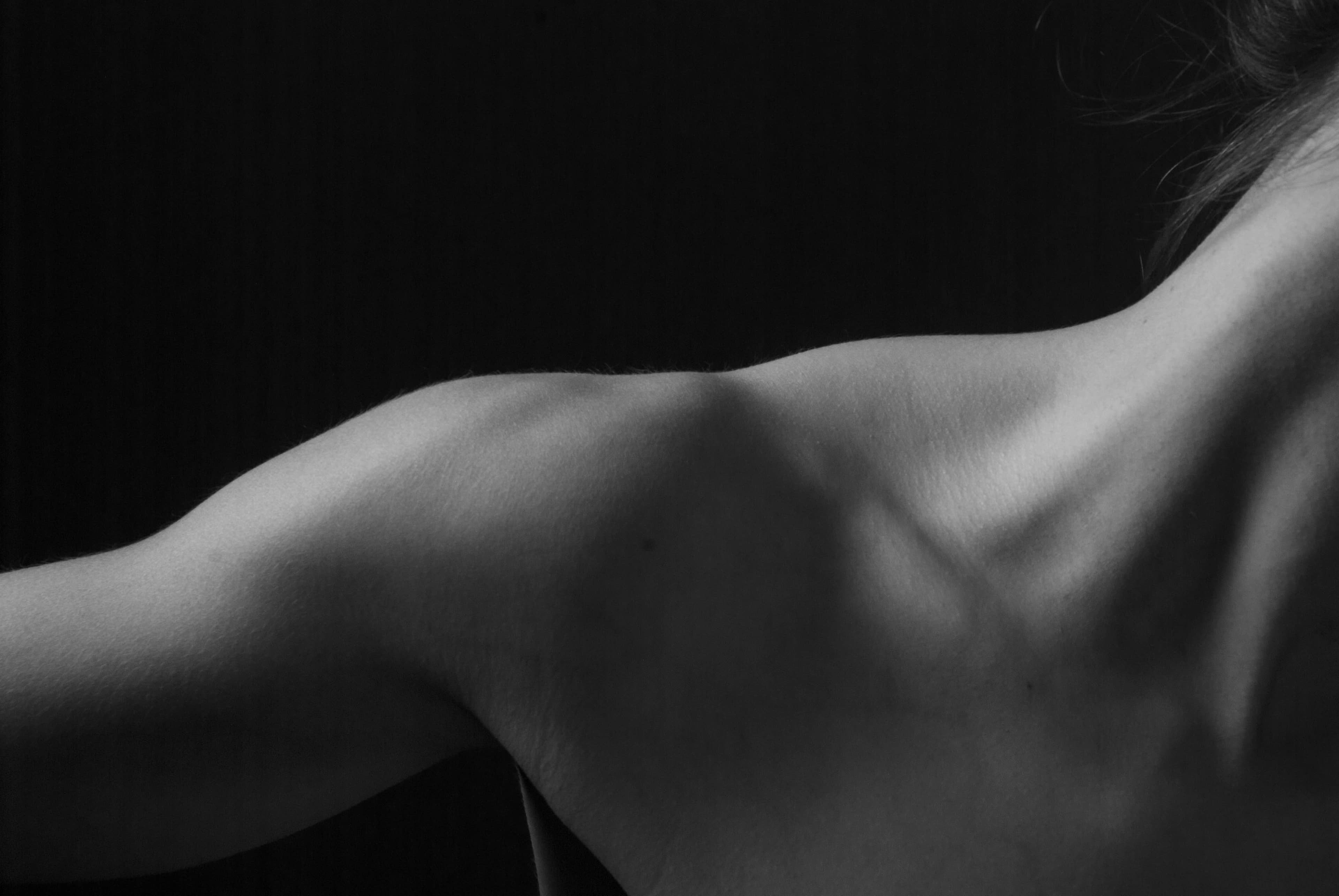 A close-up of a woman’s shoulder in soft light